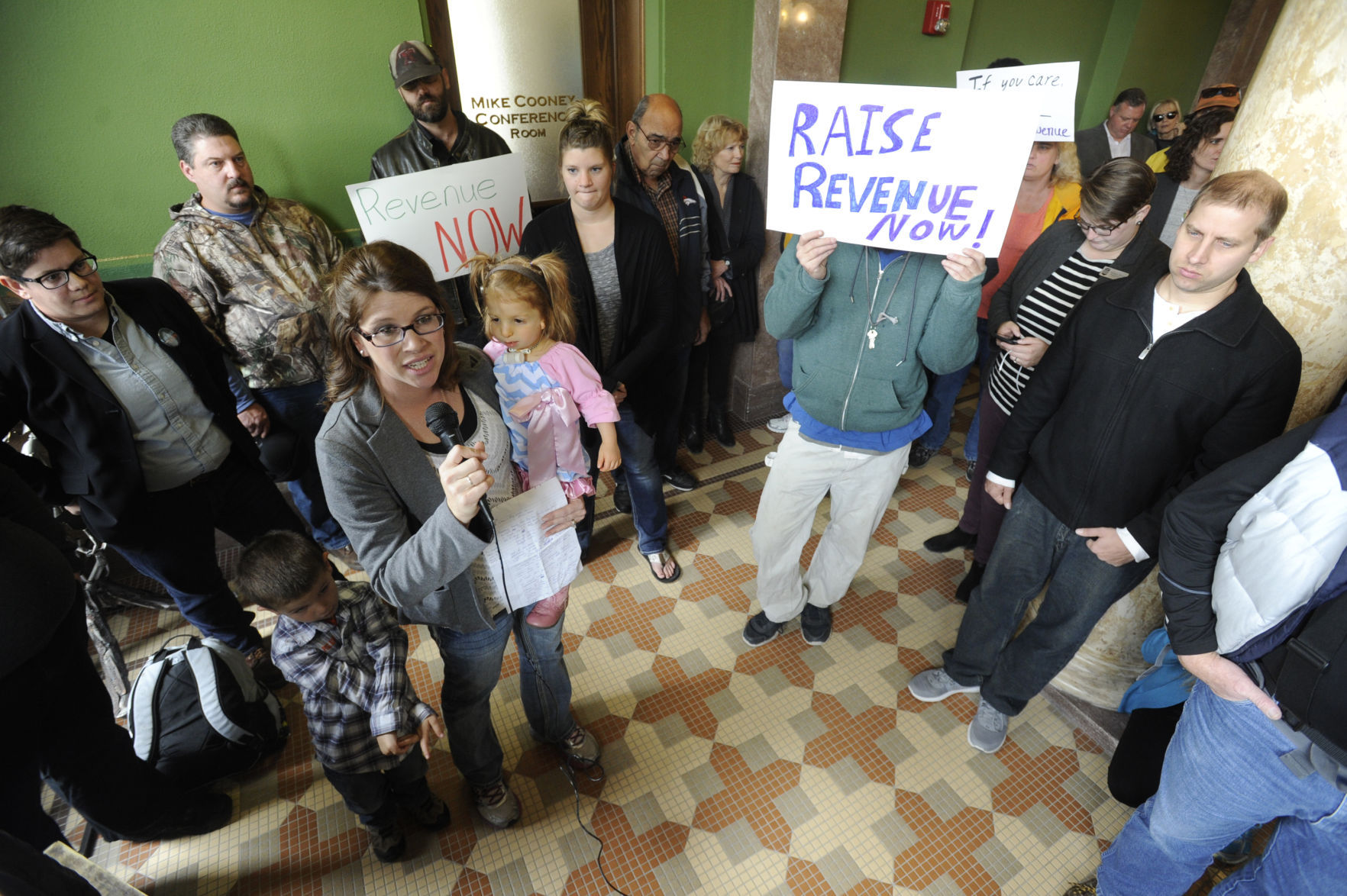 Justine Kougl from Bighorn County tells a story about her daughter Quinn, in her arms, Wednesday afternoon during the Courage not Cuts protest in the State Capitol.